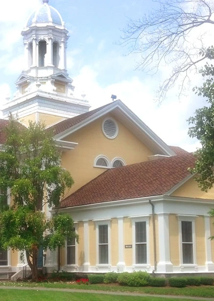 school A large yellow building with a clock tower.