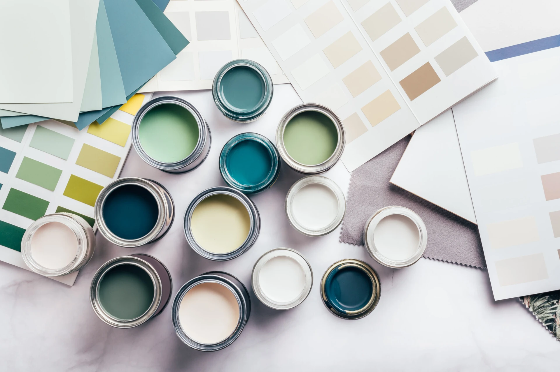 Choosing wall paints A variety of paint colors for a Commercial Exterior Painting Services project are laid out on a table.