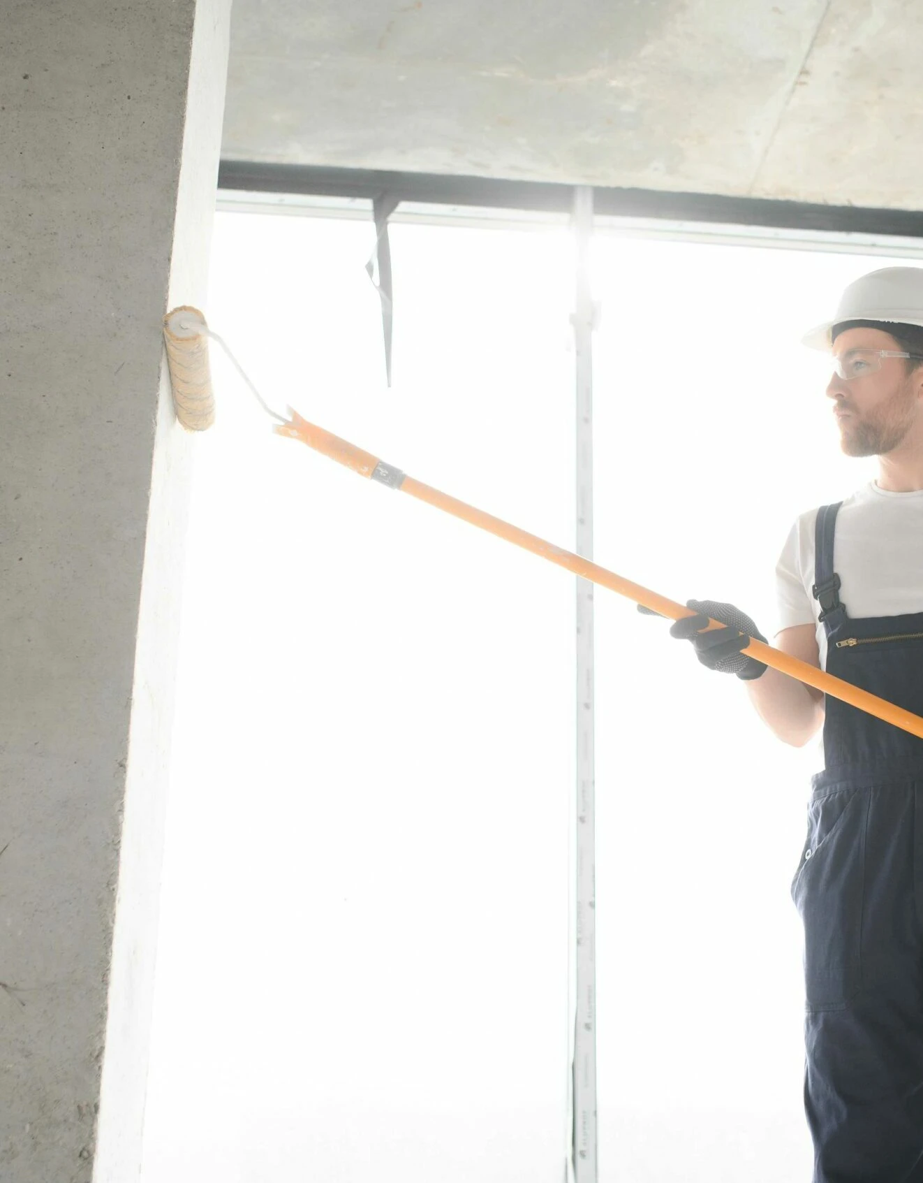 281592-painter-man-painting-the-wall-with-paint-roller-2023-09-21-05-26-48-utc Delaware Commercial Painting
