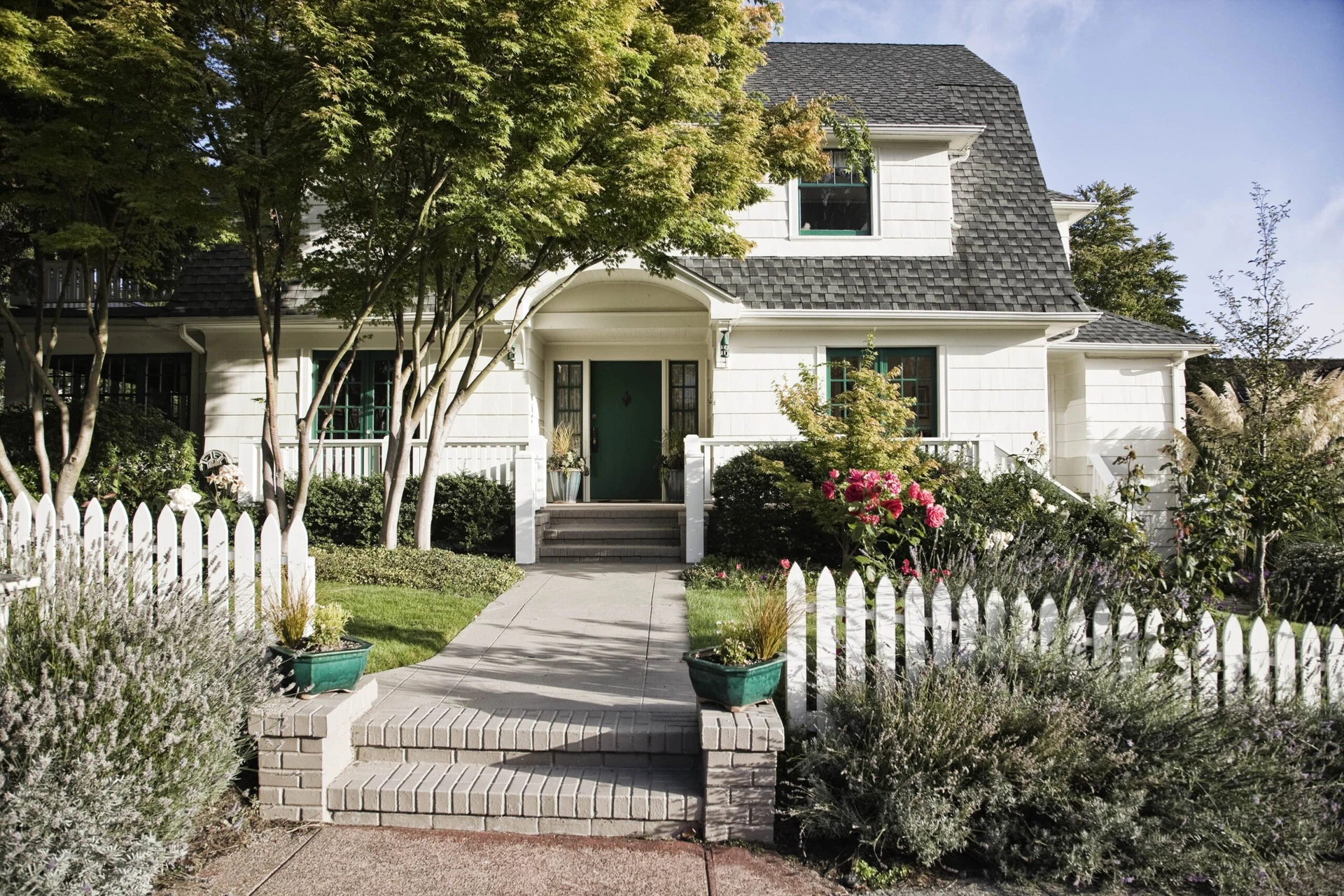 exterior-paint-job-white-home House with a white picket fence.